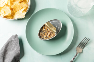 Top view of canned cockles served on turquoise dish