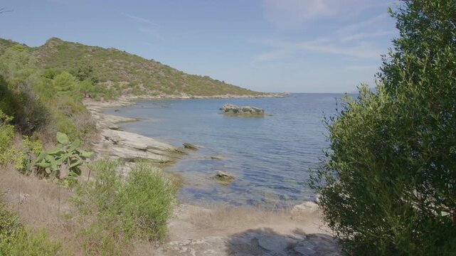 Saint-Florent Corsica coast sunny crystal clear turquoise water, rocky shorelines under a bright blue sky serene Mediterranean landscape untouched natural beauty northern Corsican seaside