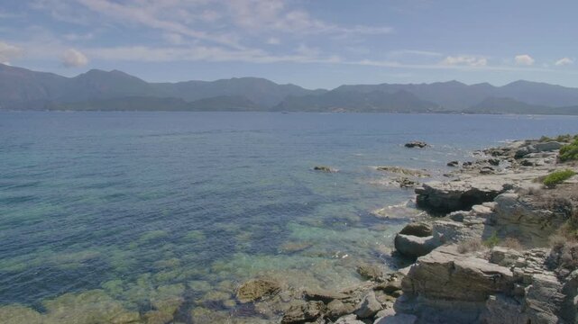 Saint-Florent Corsica coast sunny view of crystal clear turquoise waters rocky shorelines under a bright blue sky untouched natural beauty serene Mediterranean landscape northern Corsican seaside