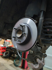 Car brake disc and pad closeup after replacement in auto repair garage
