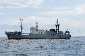 Commercial Fishing Trawler Ship on Rough Ocean Water Surface