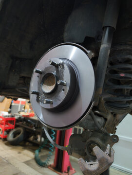 Car brake disc and pad closeup after replacement in auto repair garage