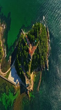  Aerial view of Fort Bregancon sunset aerial view from the mediterranean sea. A yacht is anchored near the fortress
