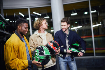 Friends enjoying a fun day choosing helmets for their exciting carting adventure