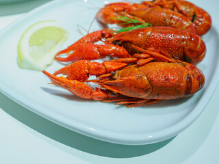 ロブスターのボイル料理　レモン添えの海鮮グルメ・白い皿のフードフォト