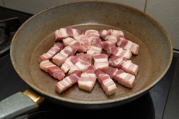 Bacon pieces frying in a frying pan, close-up.
Bacon in a hot frying pan, close-up. Frying bacon. Fried pork, chopped bacon. Fatty, high-calorie, delicious food, breakfast.