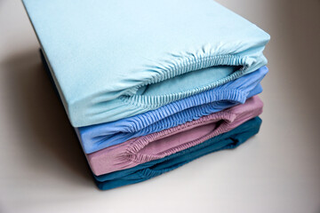 Brand new stapled fitted sheets in different colors against white background. Photo taken October 14th, 2025, Zurich, Switzerland.
