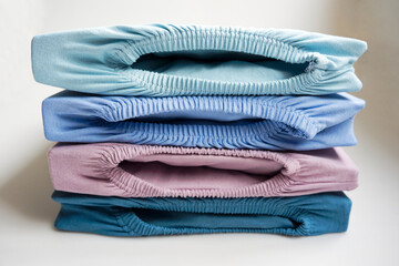 Brand new stapled fitted sheets in different colors against white background. Photo taken October 14th, 2025, Zurich, Switzerland.