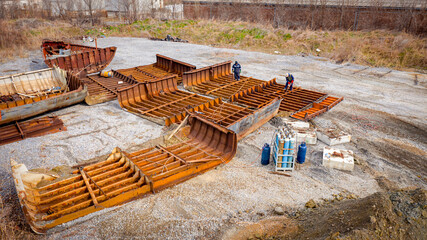 Aerial view on workers as they manually cutting old ship with blowtorch, mixing oxygen and...
