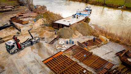 Aerial view on excavator and tow truck as they move part of vessel