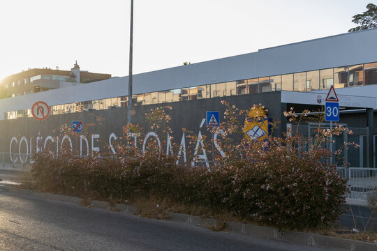 Colegio de sao tomas building in lisbon at sunset, with bushes and road signs