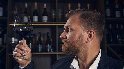 Sommelier examining color of wine in glass under warm light. Concept of professional focus, education, and sensory analysis combining precision with calm emotion.