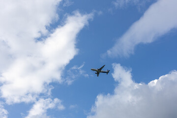 Passenger airplane flying in the sky with clouds. View from the ground. 