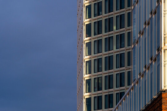 Modern glass building facade with vertical composition and soft light emphasizing geometric structure and copy space suitable for branding use