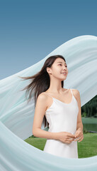 Woman in white dress with flowing fabric in outdoor setting conveying warmth and joy.