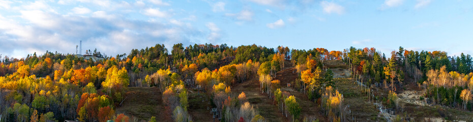 A panoramic view of a ski montain in the fall colors