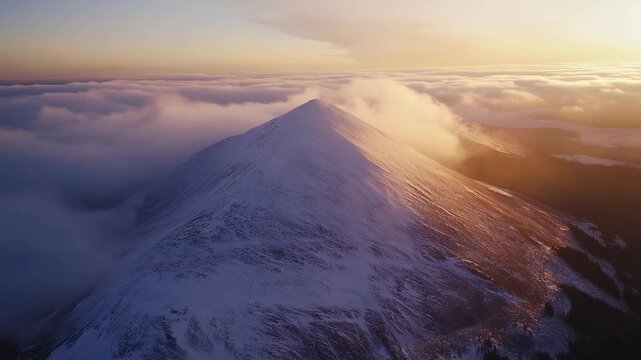 Aerial view of a majestic snowy mountain peak piercing through clouds at sunset