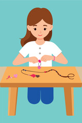 A young woman sits at a table crafting a beaded necklace with heart-shaped pendants.