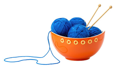 Isolated orange bowl with blue yarn balls and knitting needles against a light surface