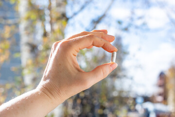 Close-up of Woman's Hand Holding Pill Capsule