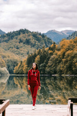 beautiful woman relax in autumn forest. Portrait of long hair woman in warm outfit walk in forest at sunset. 