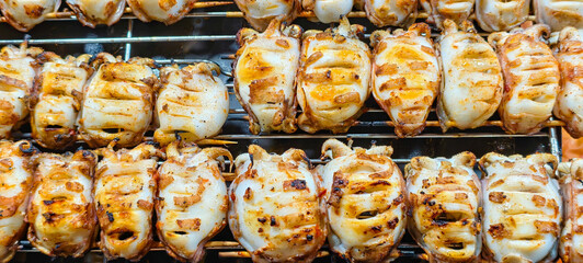 Grilled squid, a popular seafood dish in many parts of the world. It is often sold as street food and is known by different names depending on the region such as cumi bakar in Indonesia.