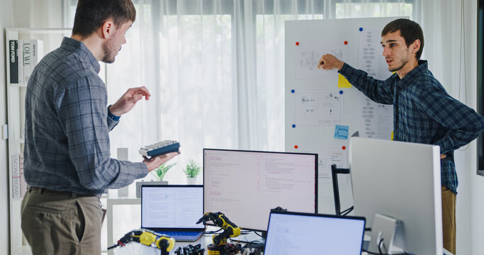 Team adult male engineer develop present AI robotics hand project at tech workspace. Artificial intelligence, collaboration support prototype development, robotic, debugging, machine learn, training.