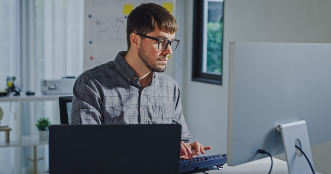 Young adult male freelance developer typing write prompt AI bot app program nomad terminal with coding at office. Artificial intelligence dashboard, robotics, user interface, machine learning concept.