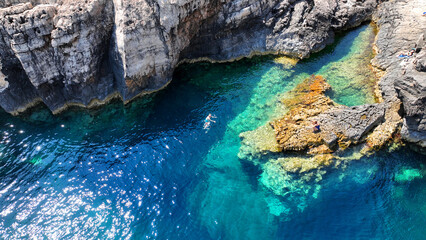 Aerial drone photo of scenic fjord shaped rock with crystal clear emerald sea ideal for snorkeling...