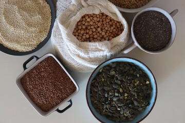 Bowls and bags full of various healthy grains and legumes. Top view.
