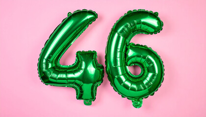 Floating shiny green foil balloon number 46 in pink backdrop, soft glowing light.