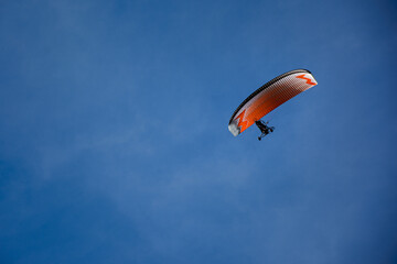 Powered paraglider. Paramotor. Microlight. ULM ultralight motorized up in the bright blue sky.
