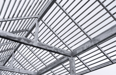Steel roof structure frame under construction with modern industrial design. Suitable for engineering, architecture, and construction industry visuals. Clear sky background