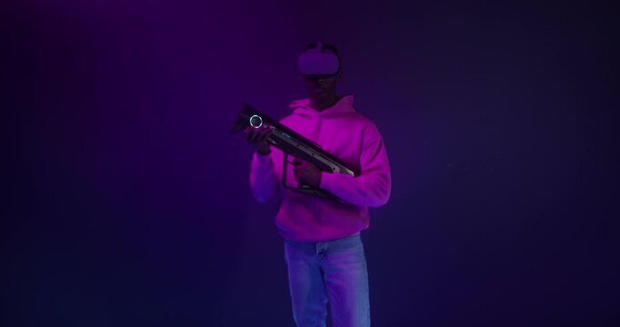 A man in a virtual reality headset with a blaster in his hands in a VR studio