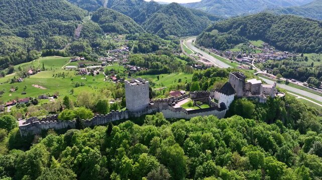 Aerial views of Slovenian landscapes in spring. Drone footage of Celje and its fortress. Historic Celje Castle overlooks vibrant spring townscape, combining medieval legacy and modern life.