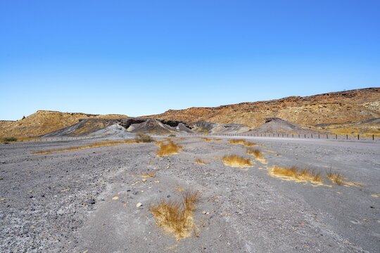 Dry landscape with yellow grass and black volcanic hills, Burnt Mountain, Damaraland, Kunene, Namibia
