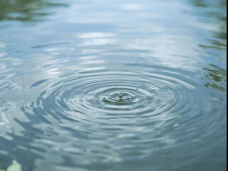 Ripples spread across calm water surface, creating soothing and tranquil effect. gentle waves reflect sky above
