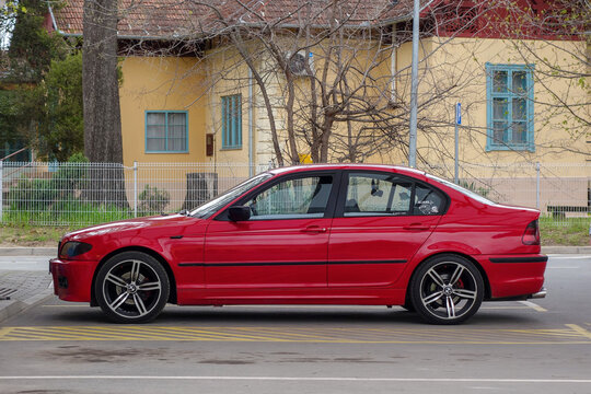 Red BMW 3-Series E46 Youngtimer sedan, side view, M-Package, modified sport wheels. Classic German engineering, popular affordable performance car. Palic, Serbia April 03, 2025