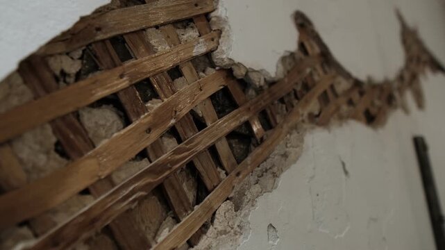 Textured vintage wall with exposed lath and cracked plaster close up background for design