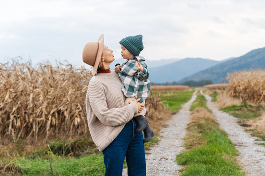 Mother and son walking playing together in agricultural field area.