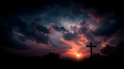 A solitary cross silhouette stands against a dramatic sunset sky with vibrant colorful clouds