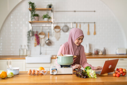 Muslim woman vlogger live streaming cooking online in kitchen look at camera with vegetables, content creator culinary class at home studio, halal food influencer cooking live, video for social media