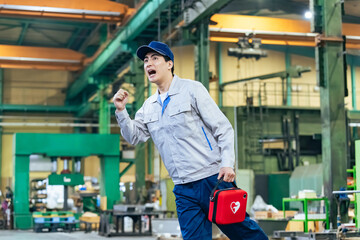 AEDを持って走る男性作業員