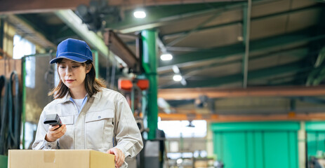 A group of female workers managing products using handheld terminals in a factory © metamorworks