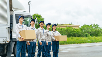 A group of delivery staff lined up in front of a truck