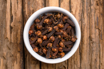 Dried cloves spice isolated on wooden background.