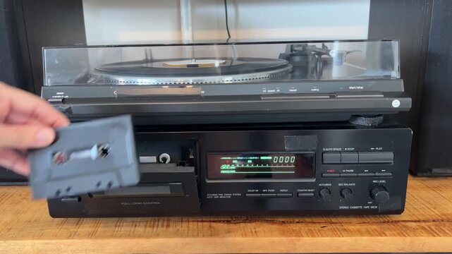 Mano de mujer introduciendo una cinta de casete y presionando el bot&oacute;n de reproducci&oacute;n, 4K