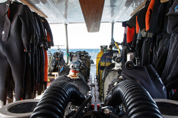 Scuba diving equipment arranged neatly on a boat, showcasing wetsuits and tanks, with ocean view in the background, emphasizing adventure and exploration in underwater activities. Red sea, Egypt
