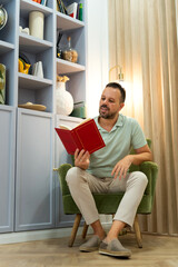 Man relaxing reading book in home library