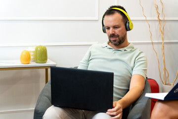 Man working remotely using laptop and headphones